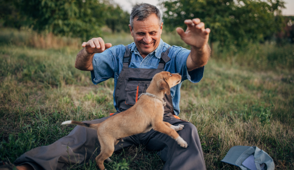 A happy man playing with a pet (dog)